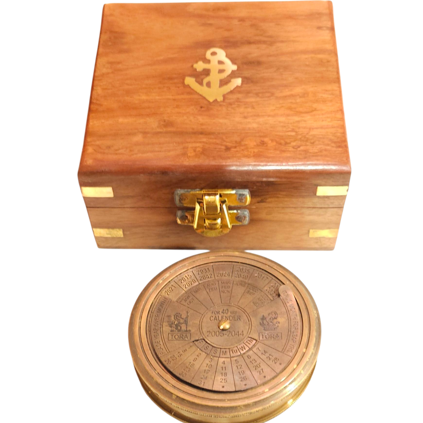 Wooden box with a gold anchor emblem and a brass calendar compass on a white background