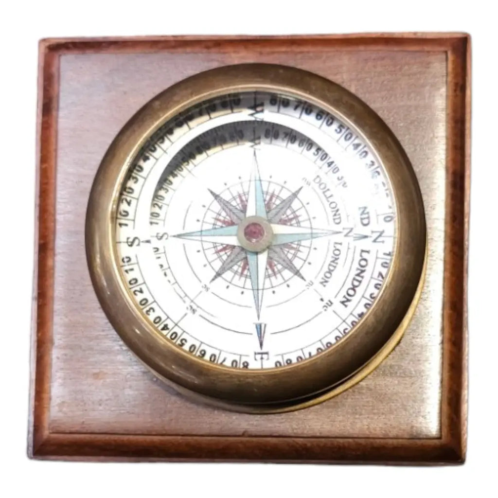 Dollond London compass | Close-up of the brass compass showing cardinal directions and vintage typography.