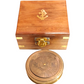 Wooden box with a gold anchor emblem and a brass calendar compass on a white background