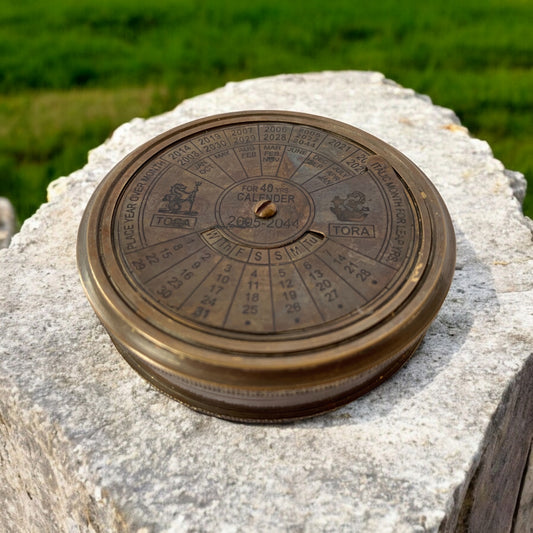 Large brass calendar compass with patina finish, featuring a functional perpetual calendar.