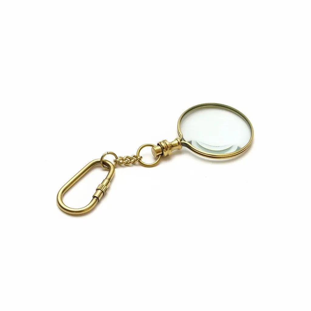 Gold magnifying glass keychain on a white background