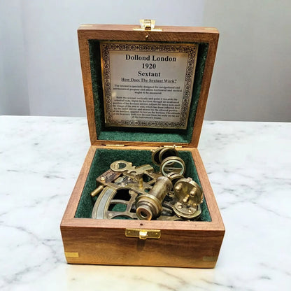 Vintage sextant in a wooden box on a marble surface