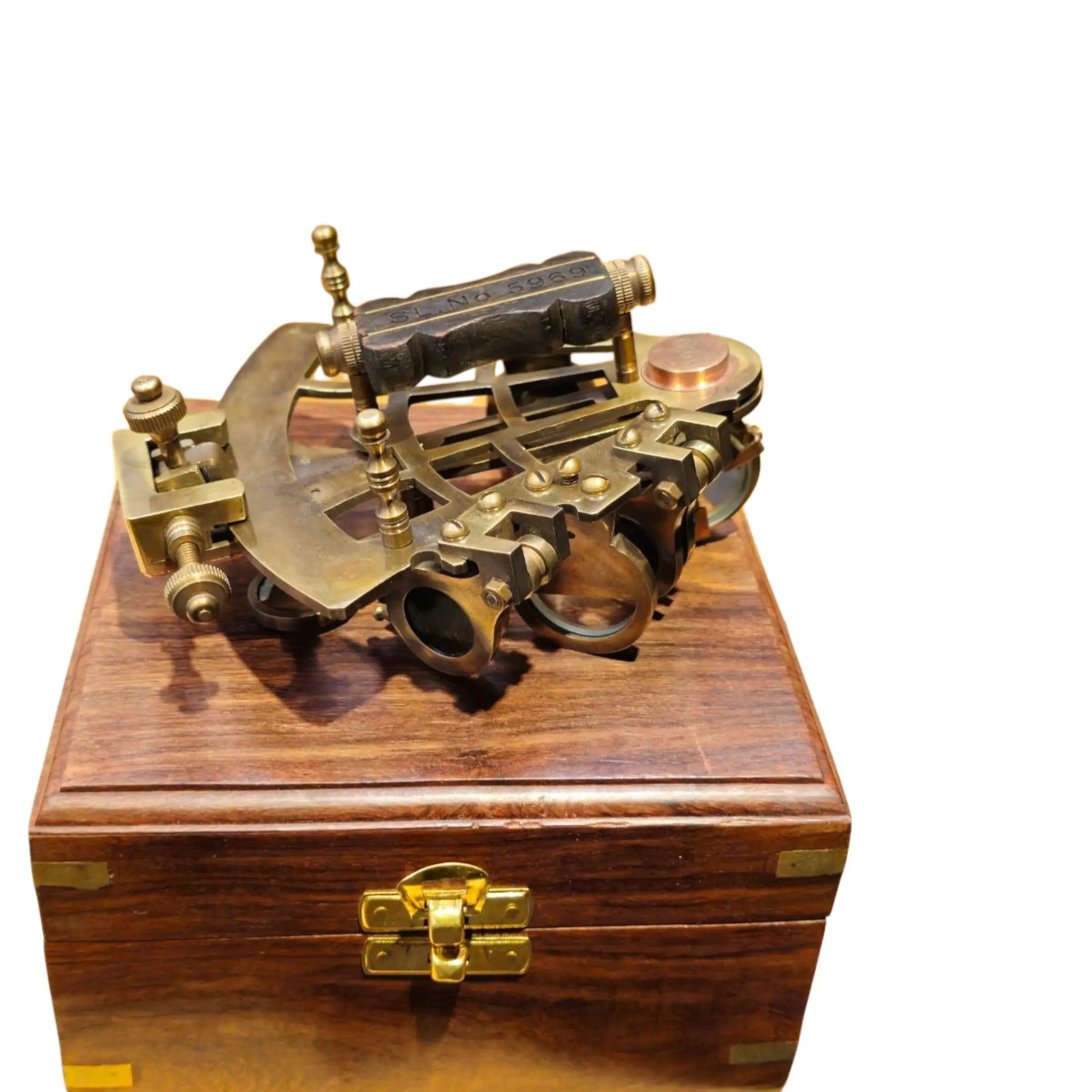 Brass sextant on a wooden box with a white background
