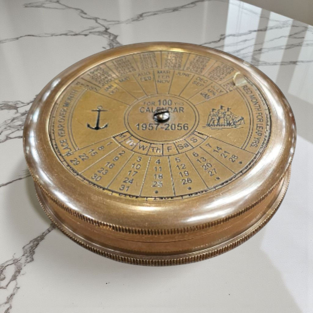 mypirateshop vintage brass perpetual calendar compass with anchor engraving and 100-year date display on marble surface