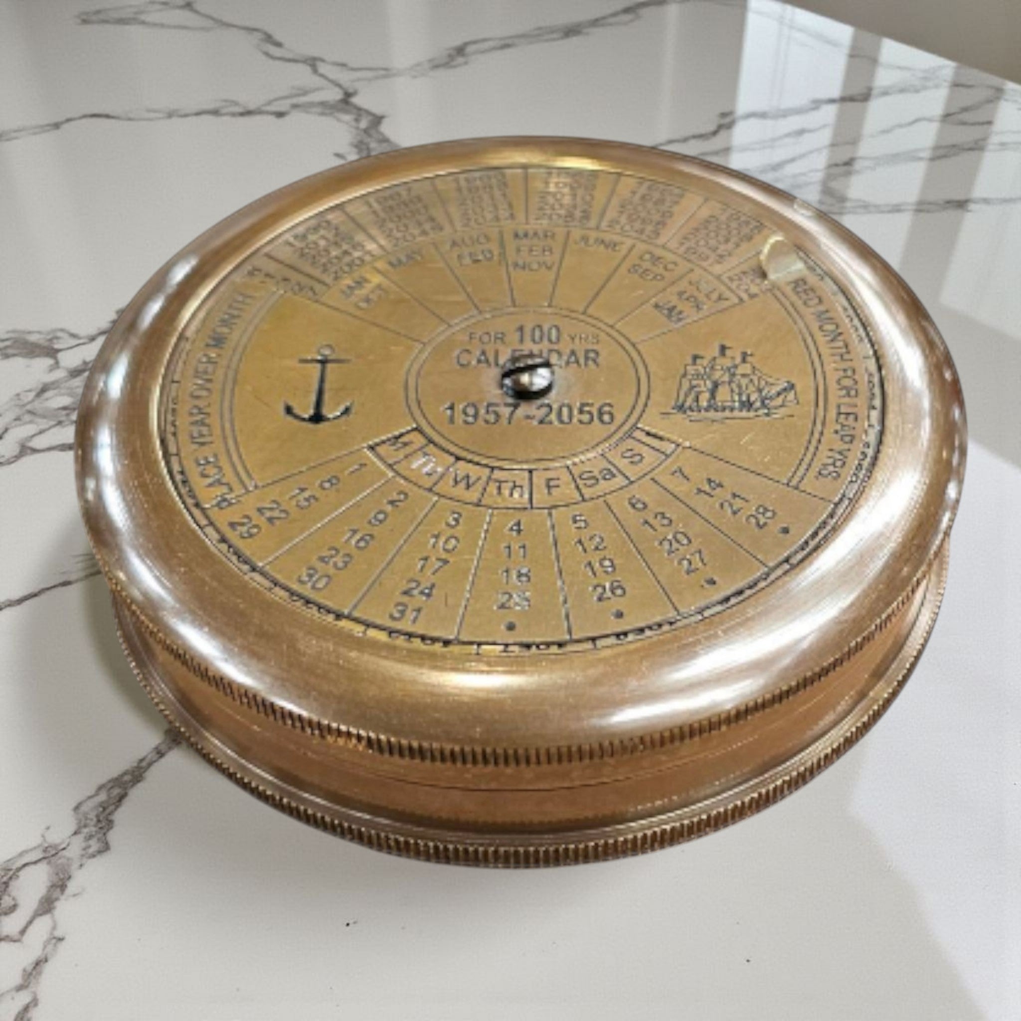 mypirateshop vintage brass perpetual calendar compass with anchor engraving and 100-year date display on marble surface